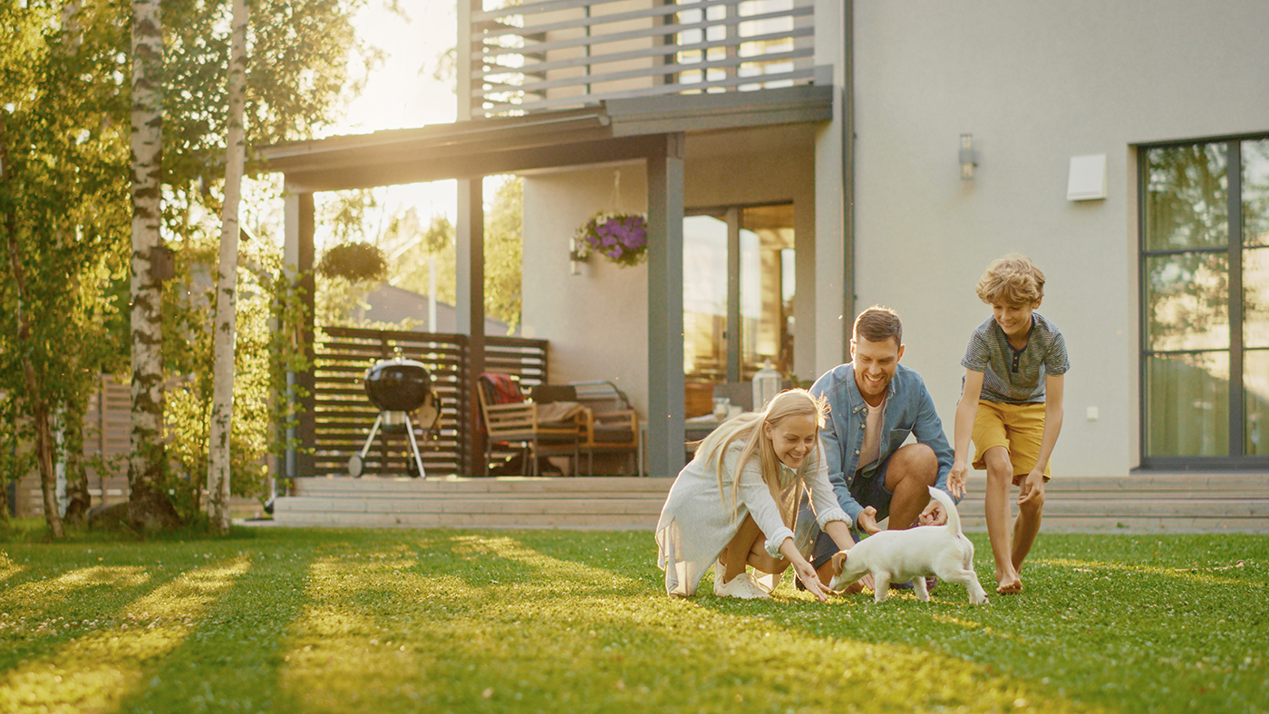 Family, with dog, in front of home